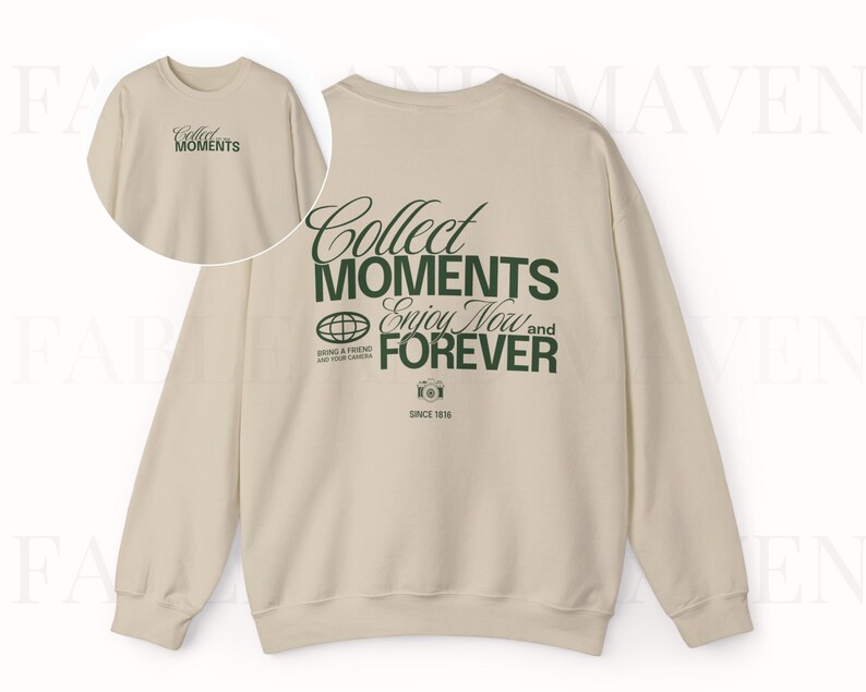 May include: A beige sweatshirt with long sleeves and a crew neck. The front of the sweatshirt has the text "Collect Moments Enjoy Now and Forever" printed in green. The back of the sweatshirt has the text "Collect Moments" printed in green.