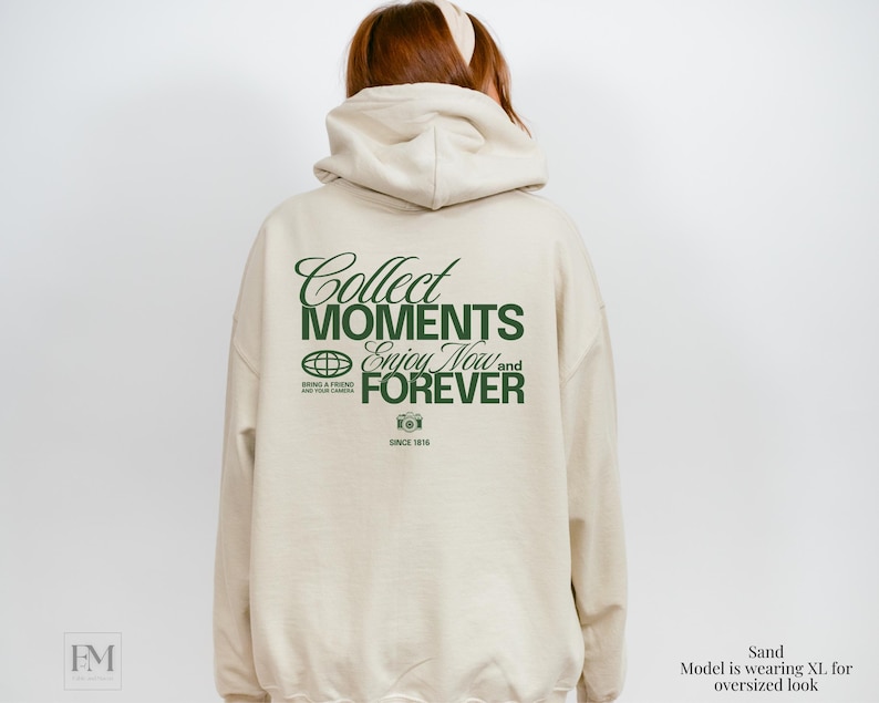 May include: A beige hoodie with a green graphic print on the back that says "Collect Moments Enjoy Now and Forever" with a camera icon and the text "Since 1816".