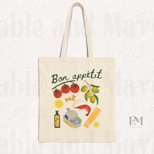 May include: A white canvas tote bag with the text "Bon app&eacute;tit" in green lettering. The bag features a colorful illustration of tomatoes, olives, lemons, pasta, sardines, and a shrimp.