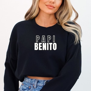 May include: A black cropped sweatshirt with white text that reads "PAPI BENITO".