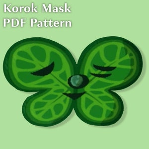 Peut inclure: Un masque en forme de trèfle à quatre feuilles de couleur verte avec un œil fermé et un petit nez rond bleu. Le masque est un patron PDF pour un masque Korok.