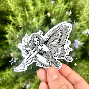 May include: A black and white sticker featuring a fairy with butterfly wings. The fairy is in a seated pose with long hair and a decorative arm band. The sticker has a white border and is surrounded by star graphics.