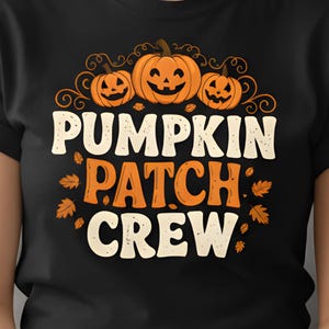 Può includere: T-shirt nera con la scritta "PUMPKIN PATCH CREW" in bianco e arancione, con grafiche di zucche e foglie. La maglietta è girocollo e viene indossata.