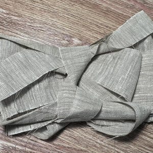 Peut inclure: Une tasse en céramique blanche avec une anse noire et le texte "But First, Coffee" en gras noir. La tasse est posée sur un fond flou, suggérant un cadre chaleureux.