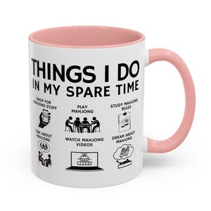White ceramic mug with pink handle featuring funny mahjong lover design “Things I Do In My Spare Time,” perfect for players and mahjong fans.