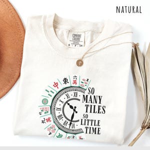 Natural comfort colors shirt with the phrase “So Many Tiles So Little Time” and colorful mahjong tiles surrounding a clock design, perfect for mahjong lovers and game night fans.