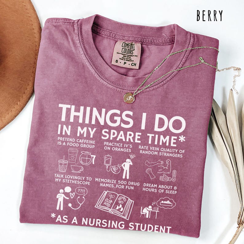 Berry colored nursing student shirt featuring the phrase Things I Do In My Spare Time as a nursing student with icons of caffeine IV practice stethoscope studying drug names and dreaming of sleep. Funny nursing student tee gift for nursing students nurse school students future nurses clinical students nursing program classmates nursing friends nurse study group members and nursing school graduates.