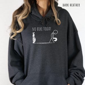 May include: Dark heather gray hoodie with the text "NO BIKE TODAY" and a white graphic of a motorcycle and a dejected stick figure. The hoodie has a drawstring hood and a front pocket.