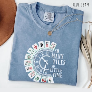 Blue jean comfort colors shirt with the phrase “So Many Tiles So Little Time” and colorful mahjong tiles surrounding a clock design, perfect for mahjong lovers and game night fans.