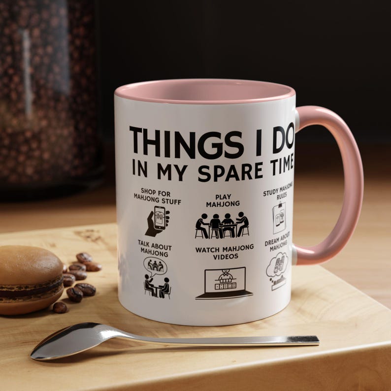 White ceramic mug with pink handle featuring funny mahjong lover design “Things I Do In My Spare Time,” perfect for players and mahjong fans.