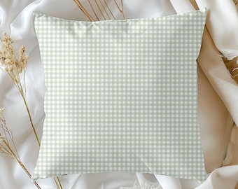 May include: Square pillow with a light green and white gingham pattern. The pillow is made of a soft fabric and is a decorative item. The pillow is a neutral color and can be used in any room. The pillow is a great addition to any home decor.