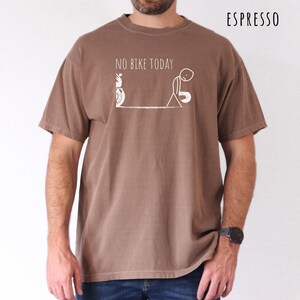 May include: Espresso-colored t-shirt with the text "NO BIKE TODAY" and a white graphic of a motorcycle and a dejected stick figure. The shirt is a short-sleeved, crew neck style.