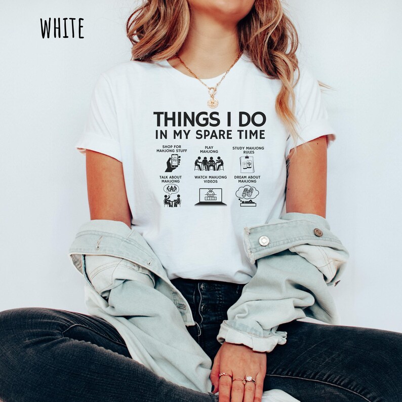 May include: White t-shirt with the text "THINGS I DO IN MY SPARE TIME" and illustrations of activities like playing mahjong, studying rules, and watching videos. The word "WHITE" is printed at the top left.