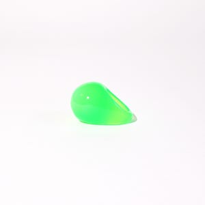 Puede incluir: Un anillo de color verde brillante, translúcido, con forma de lágrima.