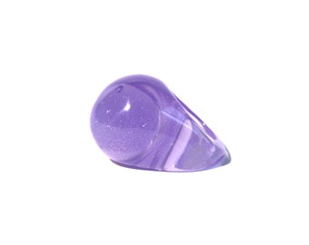 May include: A purple ring with a sparkly finish. The ring is made of resin and has a unique, asymmetrical shape.