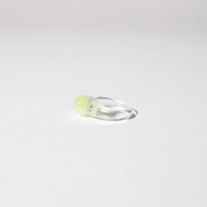 Peut inclure: Une bague transparente avec une pierre scintillante vert clair.