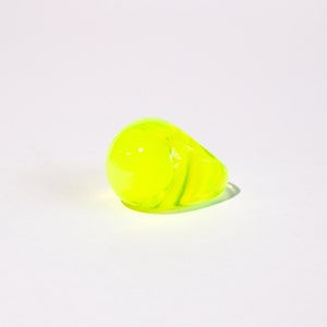 Peut inclure: Une bague jaune vif en verre avec un motif en spirale.