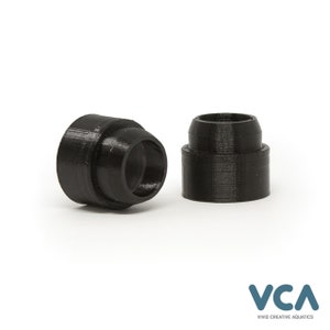 May include: Two black plastic pipe fittings, one slightly larger than the other, are shown on a white surface. The fittings are designed to connect pipes of different sizes.