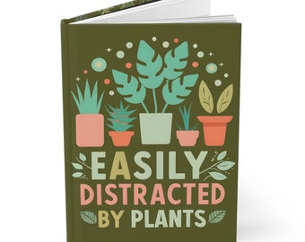 Può includere: Un diario verde con il testo "Easily Distracted by Plants" in giallo, arancione e verde. La copertina presenta un'illustrazione colorata di piante in vaso.