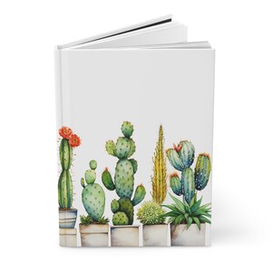 Puede incluir: Un diario blanco con una ilustración de acuarela de una fila de cactus y suculentas en macetas. Los cactus son verdes y tienen flores rojas. Las suculentas son verdes y tienen flores blancas.