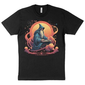 以下が含まれることがあります： 惑星に座ってキーボードを弾いている魔法使いのグラフィックがプリントされた黒いTシャツ。魔法使いは青いローブを着ていて、長い白いひげを生やしています。惑星は星と赤とオレンジの星雲の輪で囲まれています。