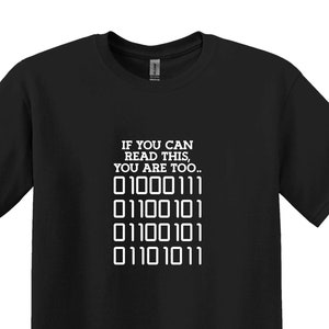 May include: Black t-shirt with white text that reads "IF YOU CAN READ THIS, YOU ARE TOO..." followed by a series of binary code: "01000111 01100101 01100101 01101011"