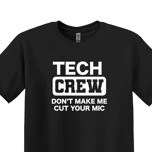May include: Black t-shirt with white text that reads "Tech Crew Don't Make Me Cut Your Mic"