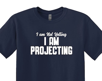 May include: A navy blue t-shirt with white text that reads "I am Not Yelling I AM PROJECTING".