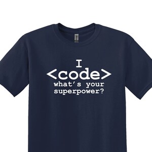May include: Navy blue t-shirt with white text that reads "I <code/> what's your superpower?"