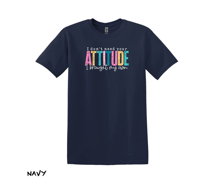 K&ouml;nnte beinhalten: Marineblaues T-Shirt mit einer wei&szlig;en Grafik, auf der "I don't need your ATTITUDE I brought my own" steht. Der Text ist in Regenbogenfarben.