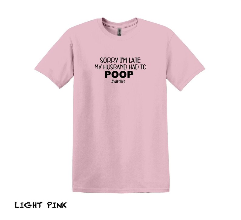 K&ouml;nnte beinhalten: Ein hellrosa T-Shirt mit dem Aufdruck "Sorry I'm late my husband had to poop #wifelife" in Schwarz.