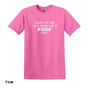 K&ouml;nnte beinhalten: Pinkes T-Shirt mit dem Aufdruck "Sorry I'm late my husband had to poop #wifelife" in wei&szlig;.