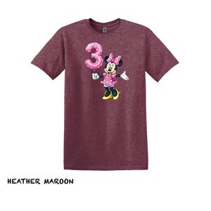 May include: A white ceramic mug with a black handle and the text "But First, Coffee" in a black, bold font. The mug is on a white surface.