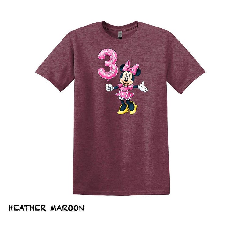 May include: A white ceramic mug with a black handle and the text "But First, Coffee" in a black, bold font. The mug is on a white surface.