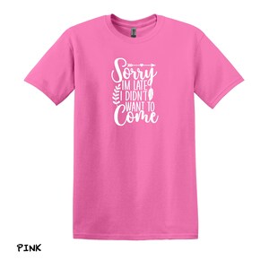 K&ouml;nnte beinhalten: Pinkes T-Shirt mit wei&szlig;em Text, der "Sorry, ich bin zu sp&auml;t, ich wollte nicht kommen" lautet.