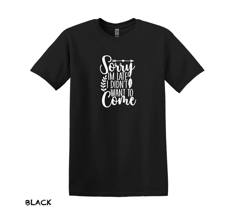 K&ouml;nnte beinhalten: Schwarzes T-Shirt mit wei&szlig;em Text, der "Sorry, ich bin zu sp&auml;t, ich wollte nicht kommen" lautet, mit einem kleinen Pfeil- und Federdesign.