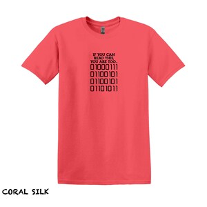 K&ouml;nnte beinhalten: T-Shirt aus Korallen-Seide mit einem schwarzen Aufdruck, der "Wenn du das lesen kannst, bist du es auch." lautet, und einer Reihe von Bin&auml;rcode: "01000111 01100101 01100101 01101011".