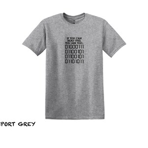 K&ouml;nnte beinhalten: Ein graues T-Shirt mit dem Text "IF YOU CAN READ THIS, YOU ARE TOO..." und einer Reihe von Bin&auml;rcode: "01000111 01100101 01100101 01101011".