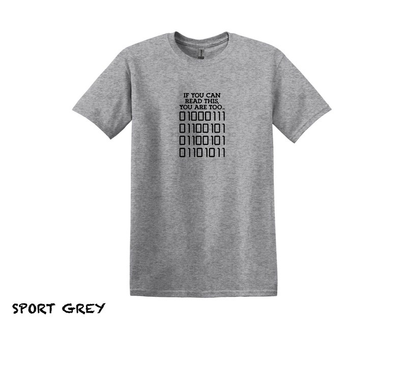K&ouml;nnte beinhalten: Ein graues T-Shirt mit dem Text "IF YOU CAN READ THIS, YOU ARE TOO..." und einer Reihe von Bin&auml;rcode: "01000111 01100101 01100101 01101011".