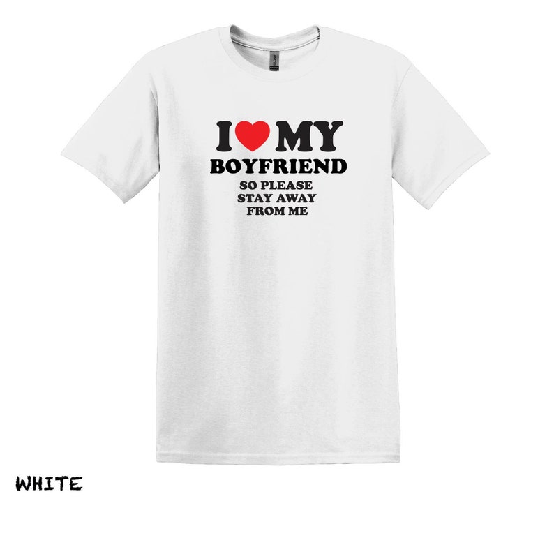 May include: White t-shirt with black text that reads "I love my boyfriend so please stay away from me". A red heart is in the text.