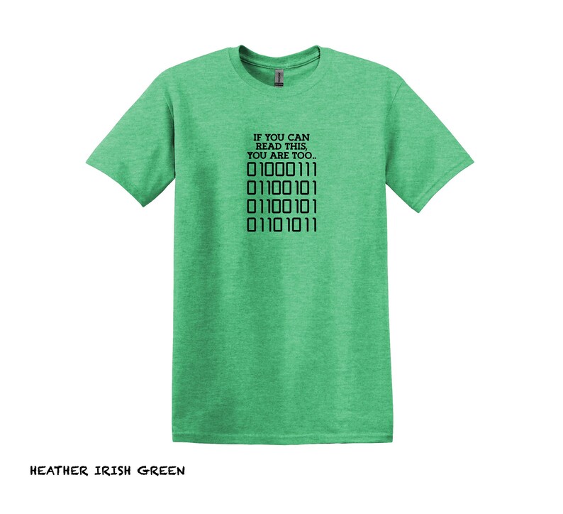 K&ouml;nnte beinhalten: Ein gr&uuml;nes T-Shirt aus Heather-Material mit dem Text "IF YOU CAN READ THIS, YOU ARE TOO..." und einer Reihe von Bin&auml;rcode: "01000111 01100101 01100101 01101011".