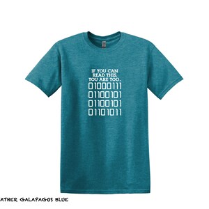 K&ouml;nnte beinhalten: Ein blaues T-Shirt mit dem Text "IF YOU CAN READ THIS, YOU ARE TOO..." und einer Reihe von Bin&auml;rcode: "01000111 01100101 01100101 01101011".