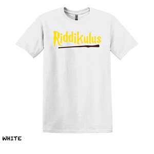 Pode incluir: Camiseta branca com o texto "Riddikulus" em letras amarelas e um gr&aacute;fico de varinha marrom.
