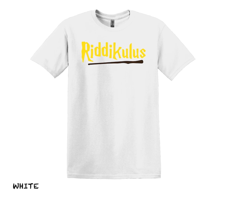 Pode incluir: Camiseta branca com o texto "Riddikulus" em letras amarelas e um gr&aacute;fico de varinha marrom.