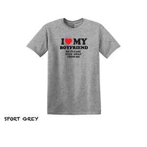 May include: A heather grey t-shirt with the text "I &hearts; MY BOYFRIEND SO PLEASE STAY AWAY FROM ME" printed in black. The heart is red.