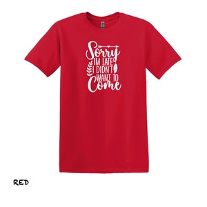 K&ouml;nnte beinhalten: Rotes T-Shirt mit einem wei&szlig;en Aufdruck, der "Sorry, ich bin zu sp&auml;t, ich wollte nicht kommen" mit einem Pfeil und Bl&auml;ttern sagt.