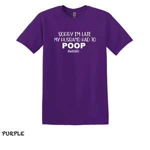 K&ouml;nnte beinhalten: Lilafarbenes T-Shirt mit dem Aufdruck "Sorry I'm late my husband had to poop #wifelife" in wei&szlig;.