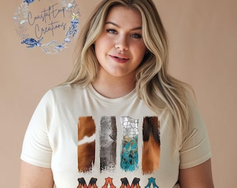 May include: A woman wearing a cream colored t-shirt with a graphic design of colorful abstract shapes and the word "MAMA" in a decorative font.