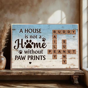 May include: A blue and white wooden sign with the text "A house is not a home without paw prints" and a scrabble tile design spelling out "Buddy, Ail, Sun, Peanut, Yany".