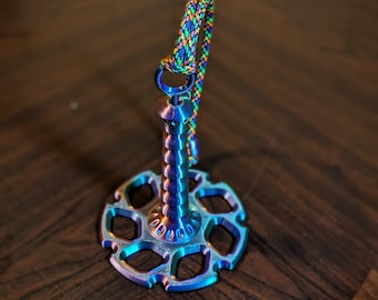 May include: A multi-colored metal keychain with a spiral design and a star-shaped base. The keychain has a colorful braided cord attached to the top.